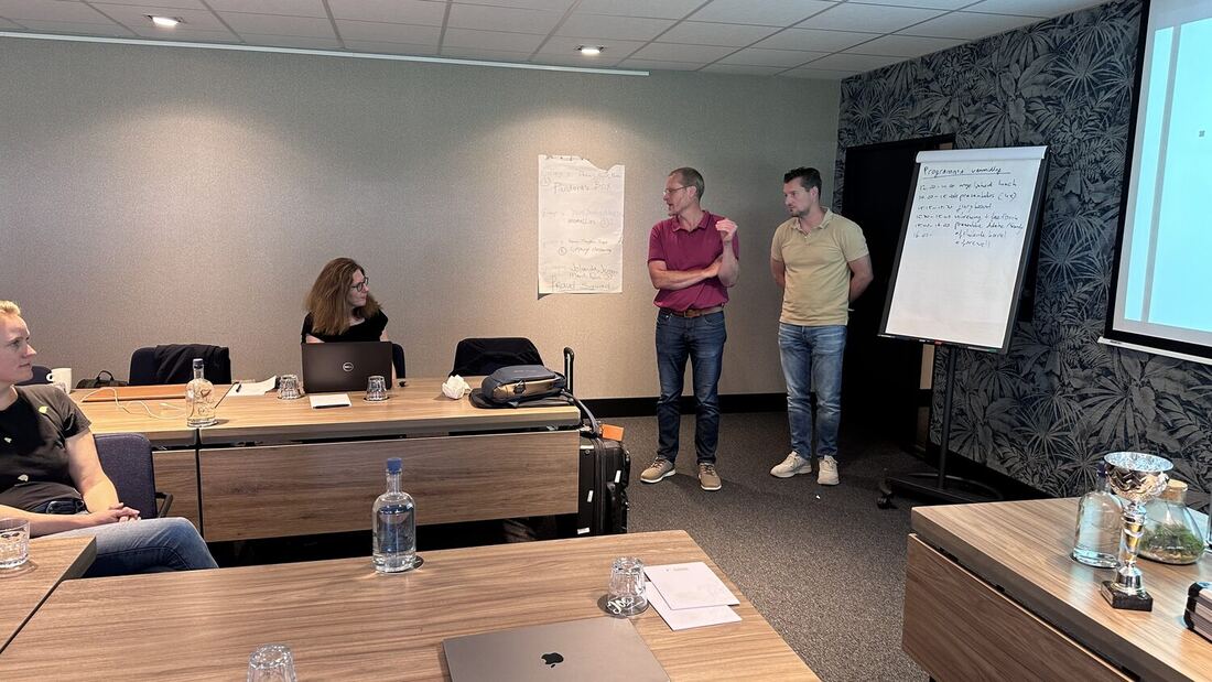 A delegate at the table while two others work at the flip chart.