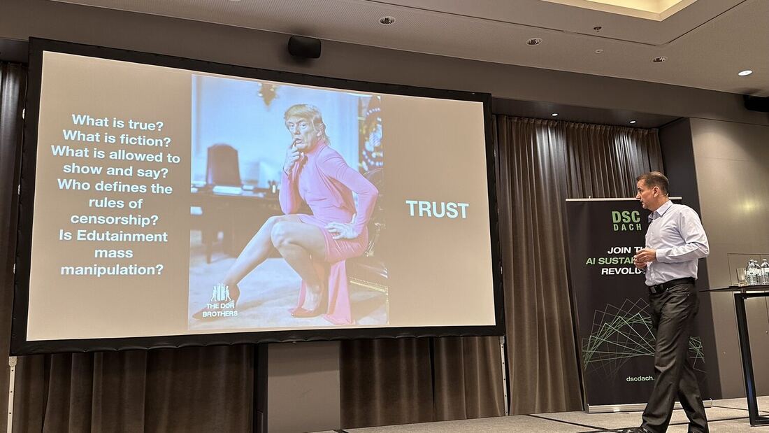 A speaker beside a slide headed Trust, listing questions about truth, fiction, censorship and mass manipulation.