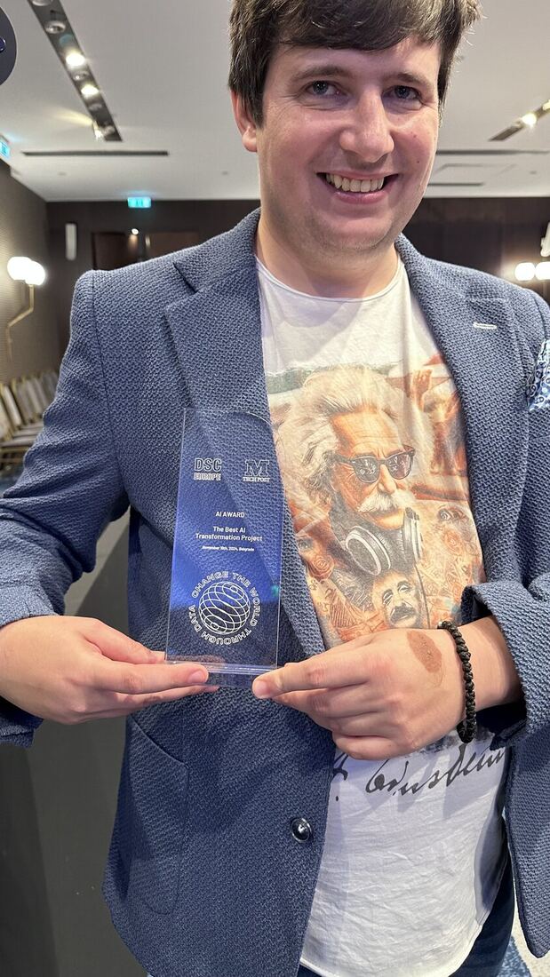 A delegate holds up the glass DSC Europe and Marktechpost AI Award engraved The Best AI Transformation Project, November 19th, 2024, Belgrade