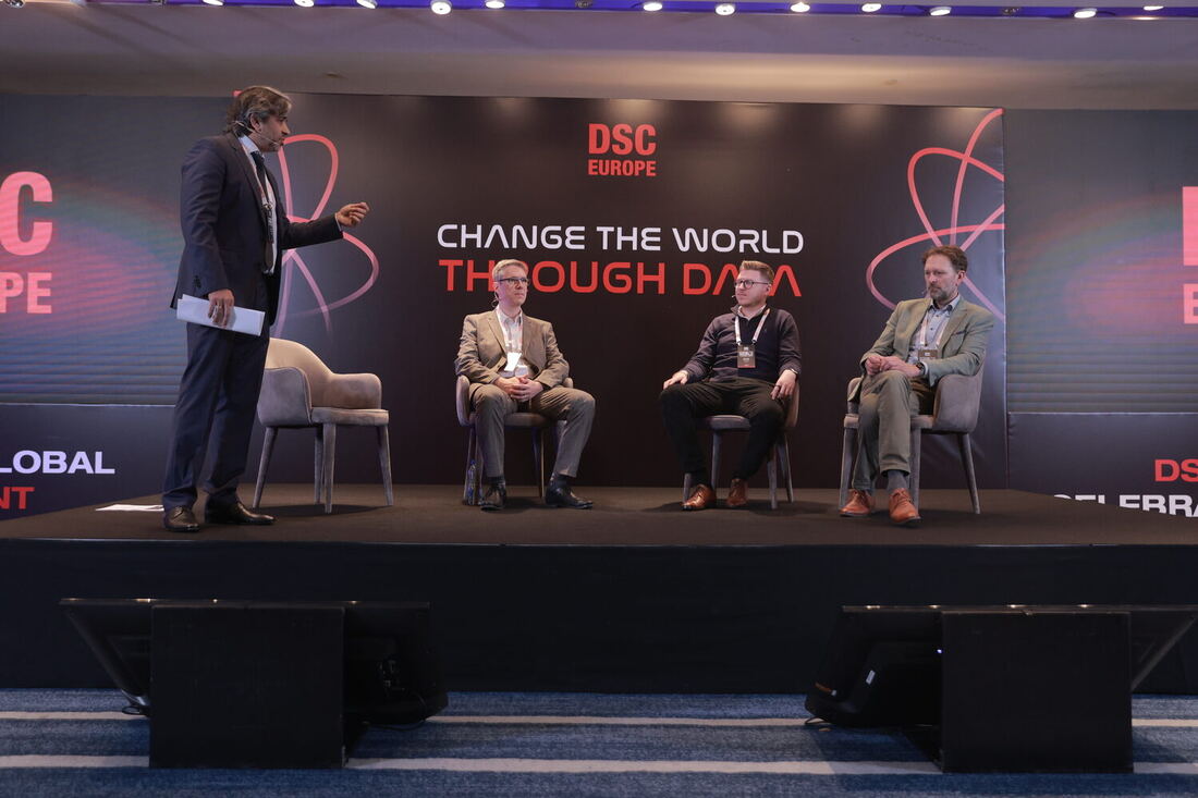 The moderator stands to put a question to the seated panel
