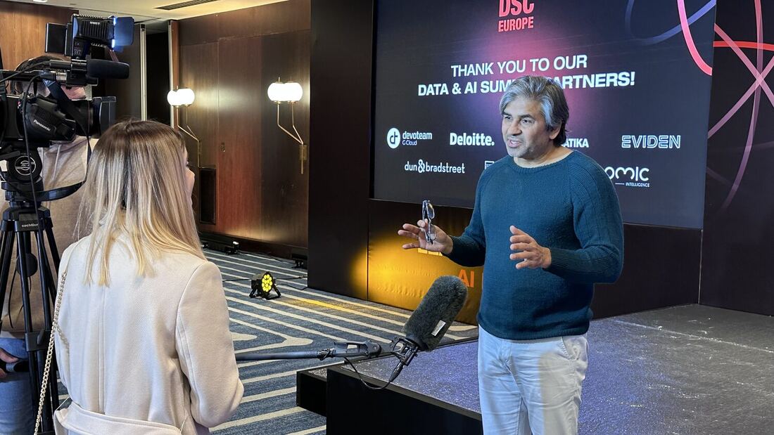 An interviewer and subject in front of the main screen