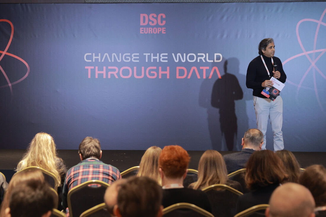 A speaker in front of the Change the world through data screen