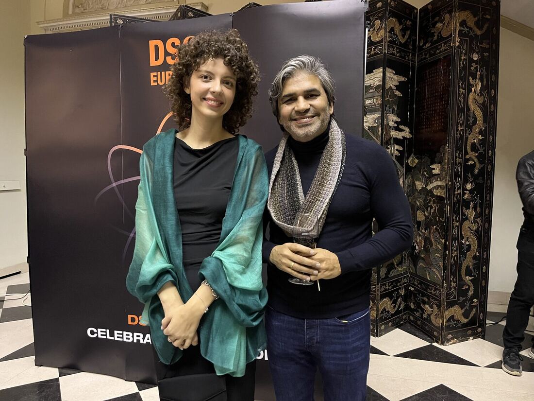 Two people photographed together at the DSC Europe branded wall