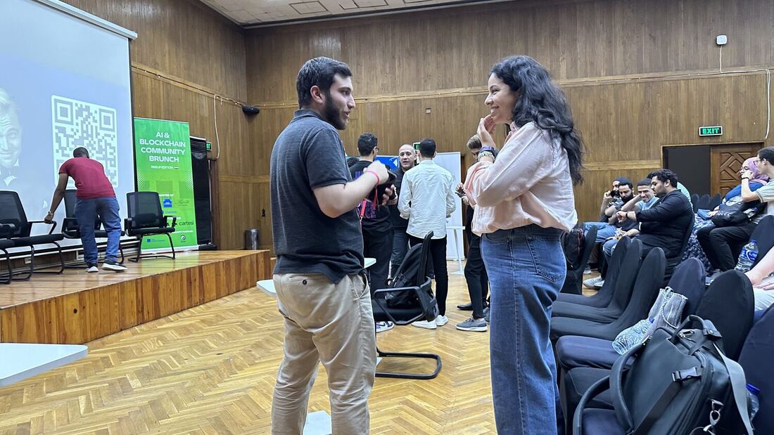 Auditorium in central Cairo with the AI & Blockchain Community Brunch, RiseUp Edition banner beside the stage