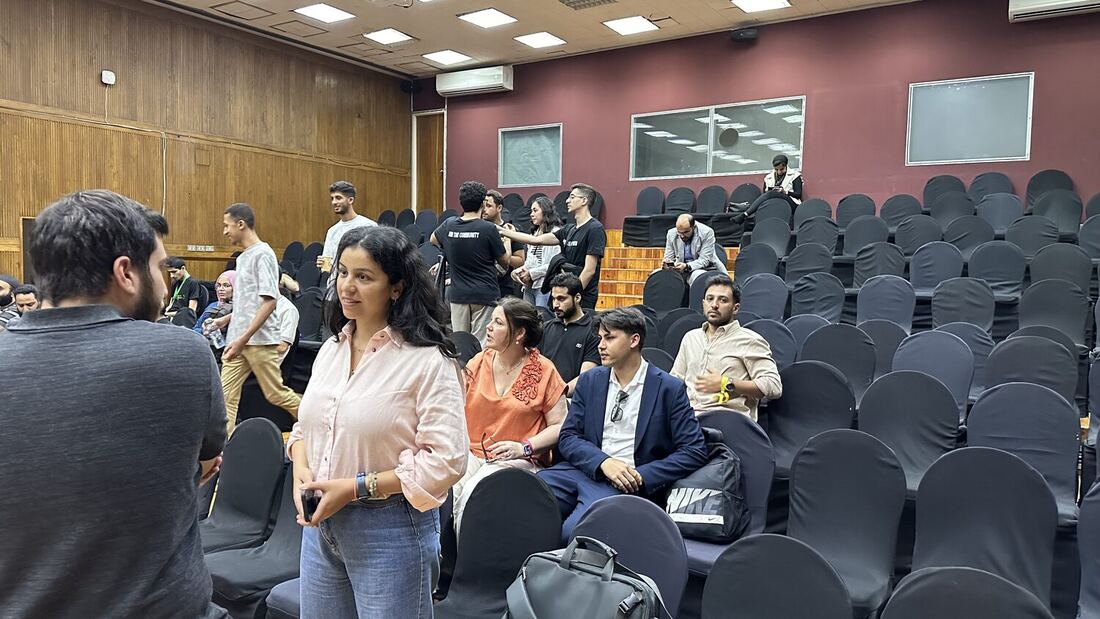 Delegates and local attendees in the raked seating of the Cairo auditorium between sessions