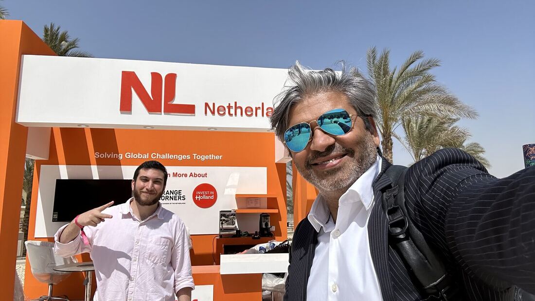 Two delegates standing in front of the NL Netherlands pavilion during the summit