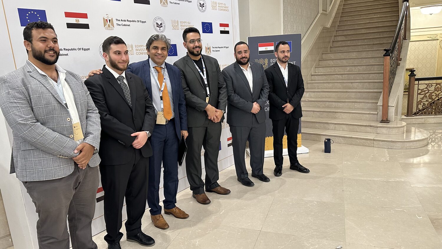 Six delegates photographed at the step-and-repeat wall carrying the Egyptian Cabinet, GAFI and European Union marks.