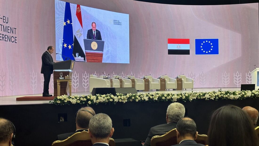 El-Sisi at the lectern seen from the floor of the hall, delegates seated in the rows in front of the stage.