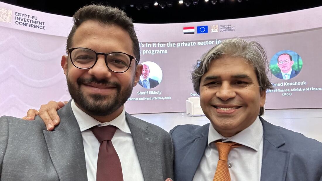 Two delegates in front of the session screen on what the programmes hold for the private sector, naming Sherif Elkholy of Actis and Ahmed Kouchouk of the Ministry of Finance.
