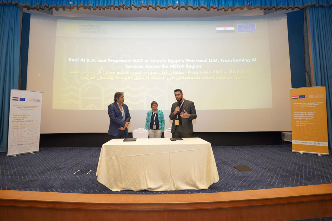 Wide view of the conference stage with the signing party in place, conference pull-up banners on either side reading about leapfrogging traditional development paths and nearshoring investment.
