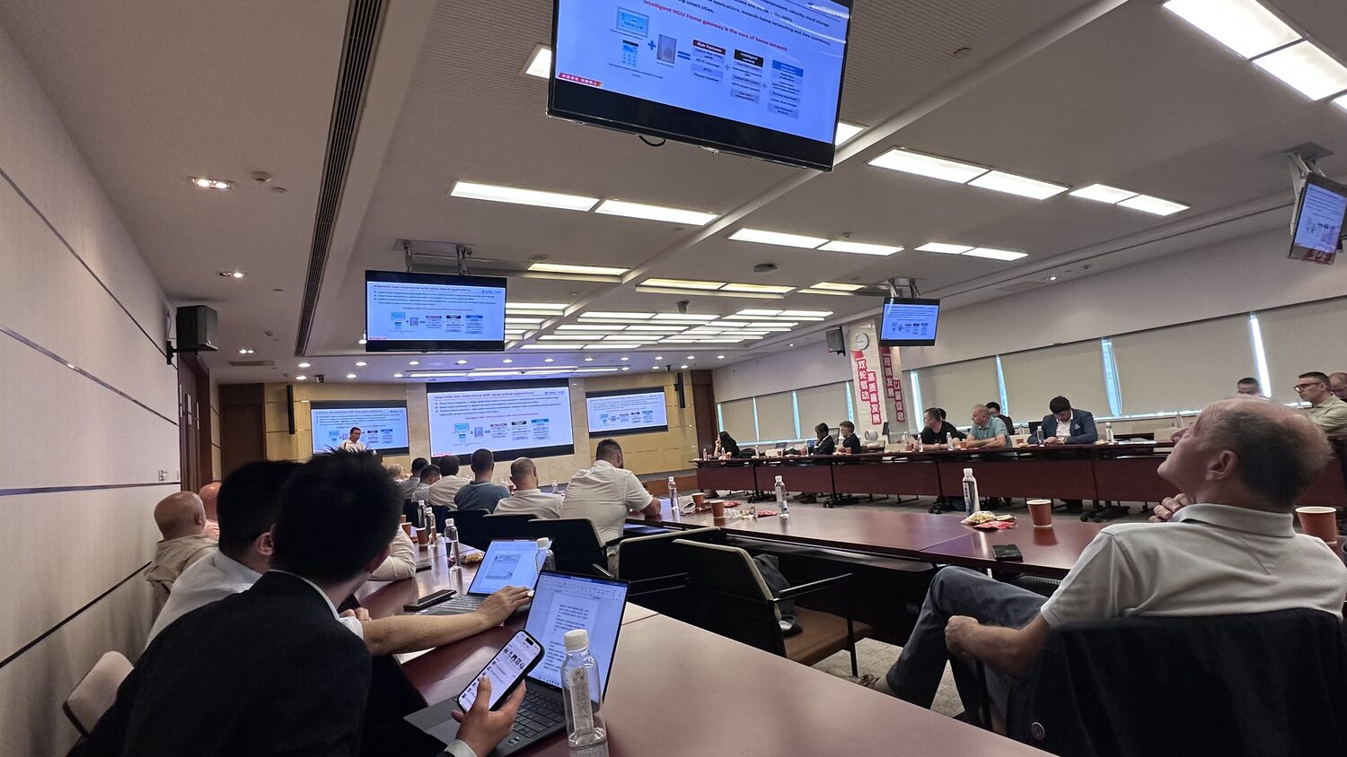Briefing room in Pudong, Shanghai, 3 July afternoon, several ceiling-mounted screens carrying the same slide, delegates on both sides.