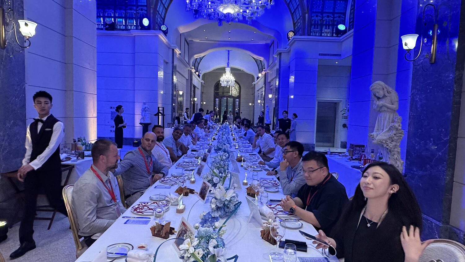 Evening reception, 30 June: a long banquet table under blue light, European delegates and Chinese hosts seated together.