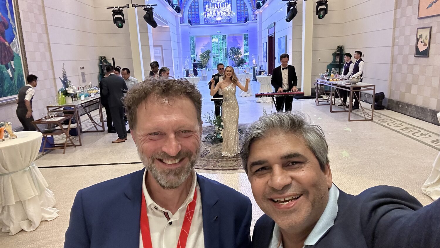 Two delegates with event lanyards at the evening reception, Shenzhen, 30 June.