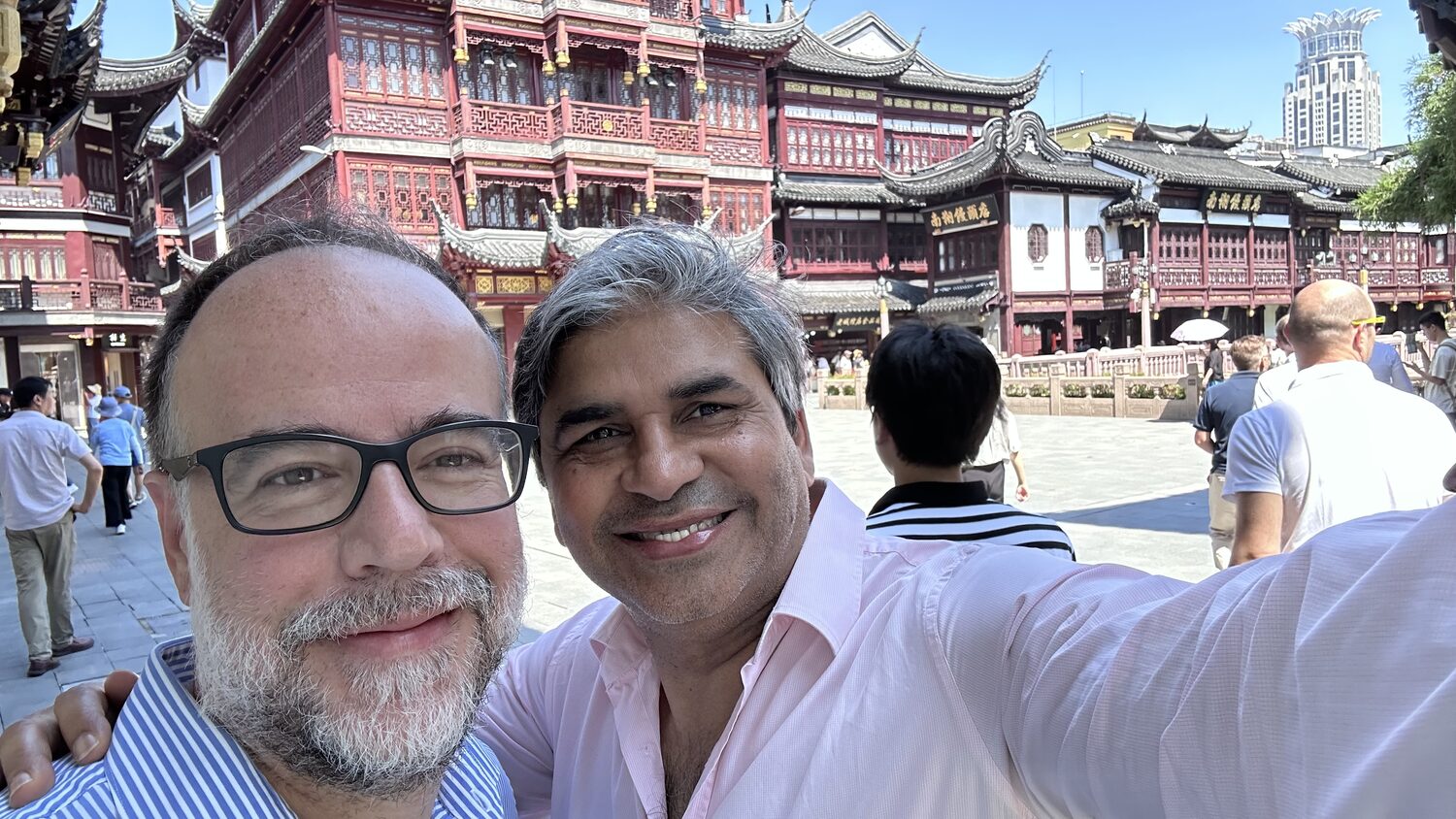Two delegates in the Yuyuan bazaar square, Shanghai, with the tiered Ming-style facades behind, 3 July.
