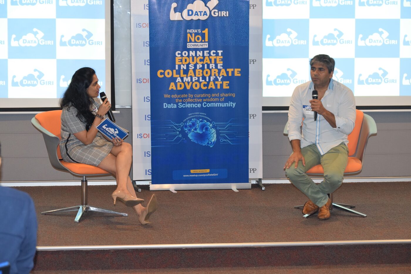Fireside session on stage, the DataGiri host seated with a microphone on the left and Tarry Singh answering on the right, a DataGiri banner between them.