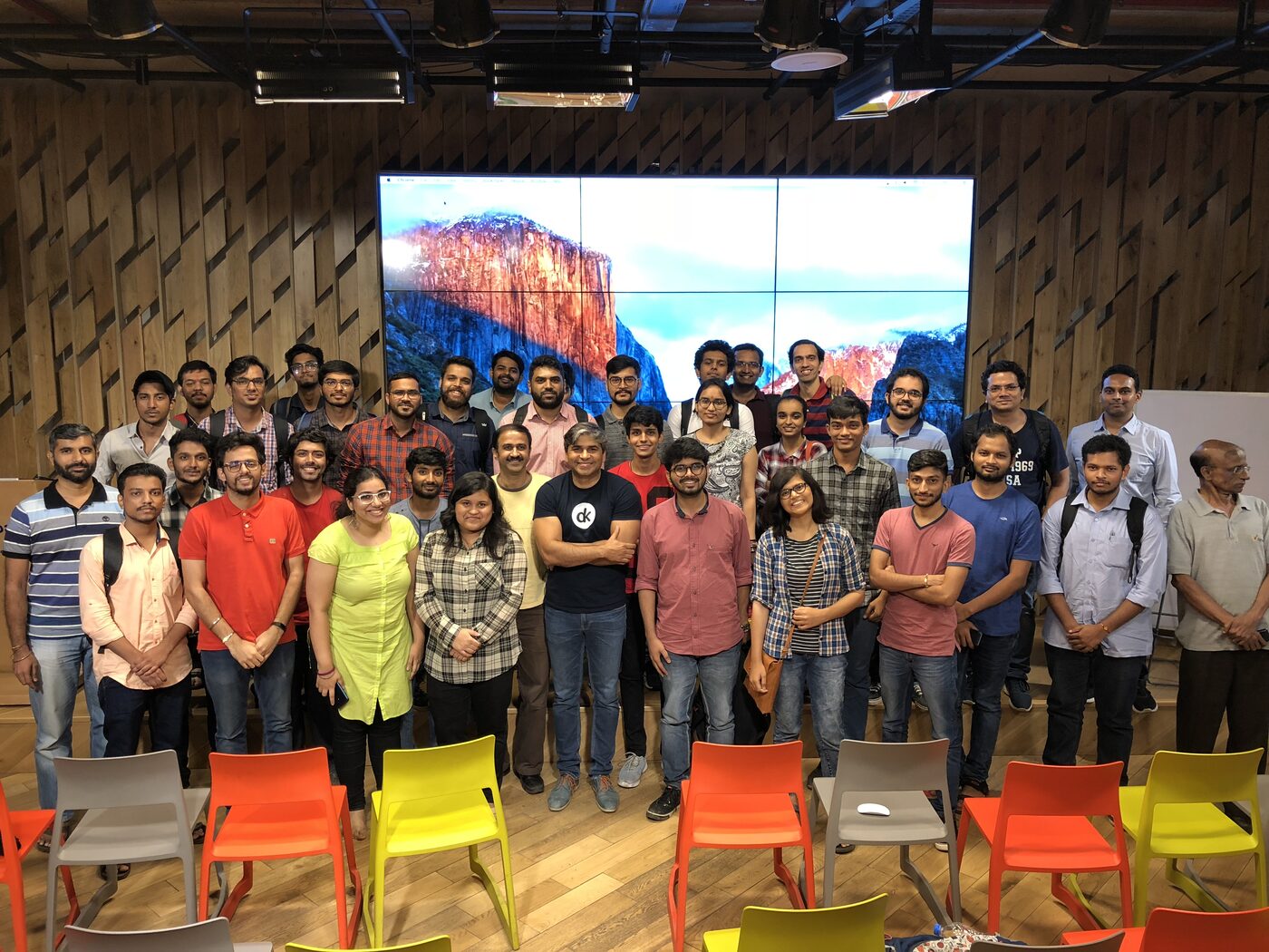 Group photo with the PyData Mumbai meetup cohort standing in front of the venue's video wall.