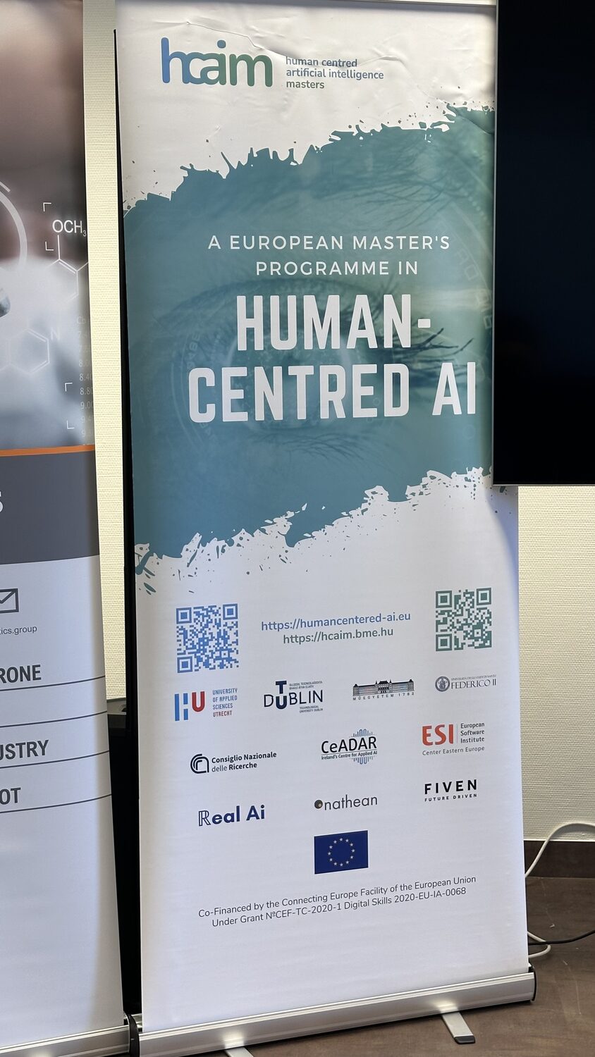 HCAIM roll-up banner in the venue reading A European Master's Programme in Human-Centred AI, with partner logos including Real Ai.