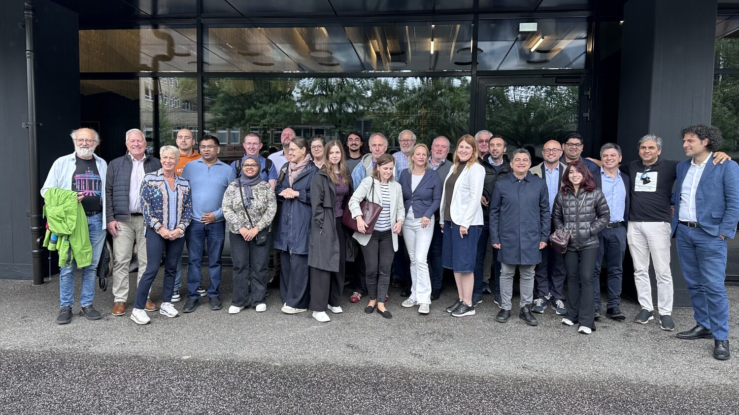 About thirty members of the PANORAIMA consortium standing outside the glass entrance of Satellite Nine, Steindamm 94, Hamburg, on the morning of 12 June 2026.
