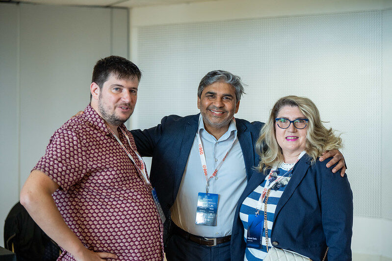 Tarry Singh with two delegates wearing DSC lanyards at the conference venue.
