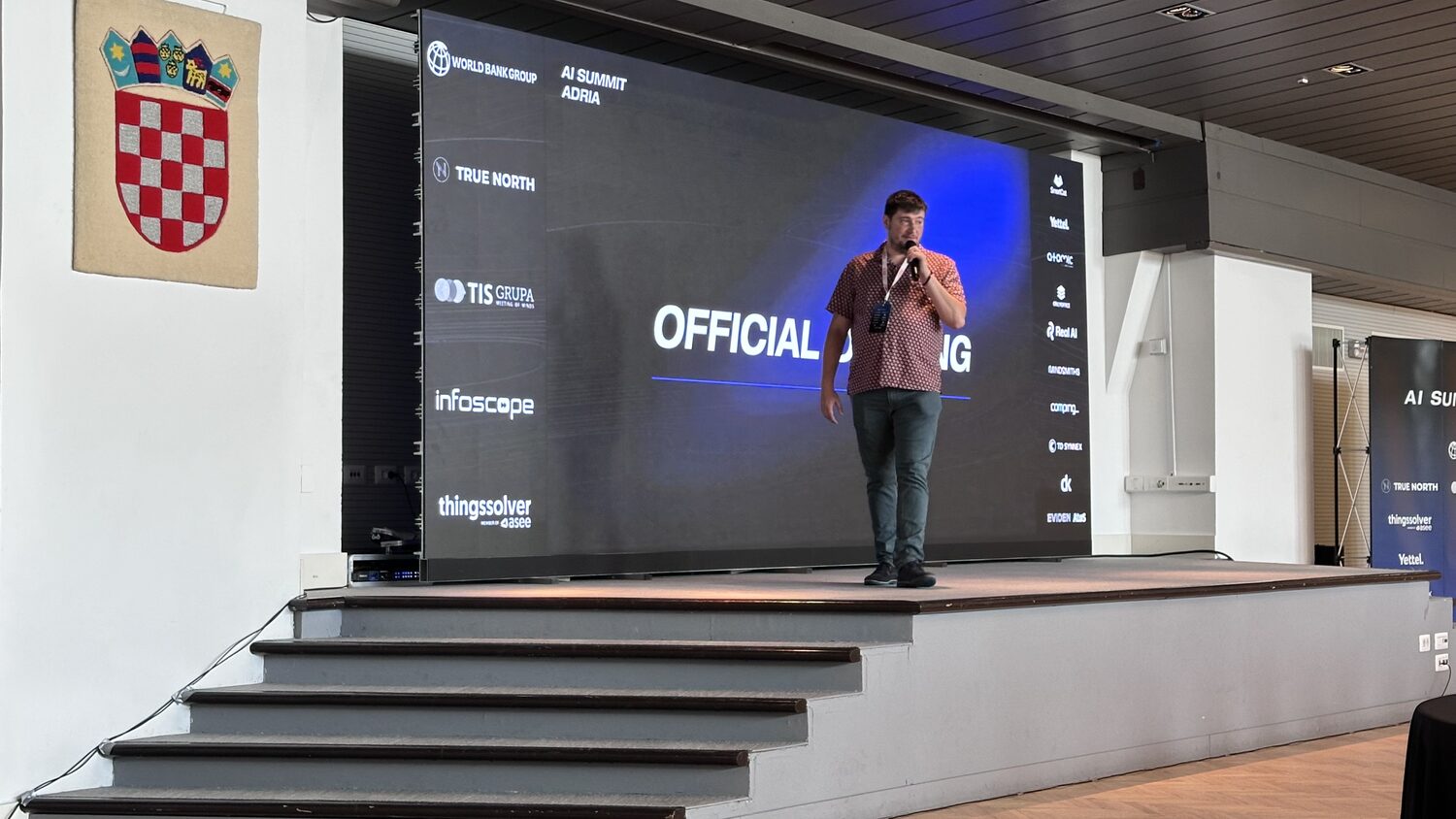 The official opening of AI Summit Adria, a host alone on stage with a microphone.