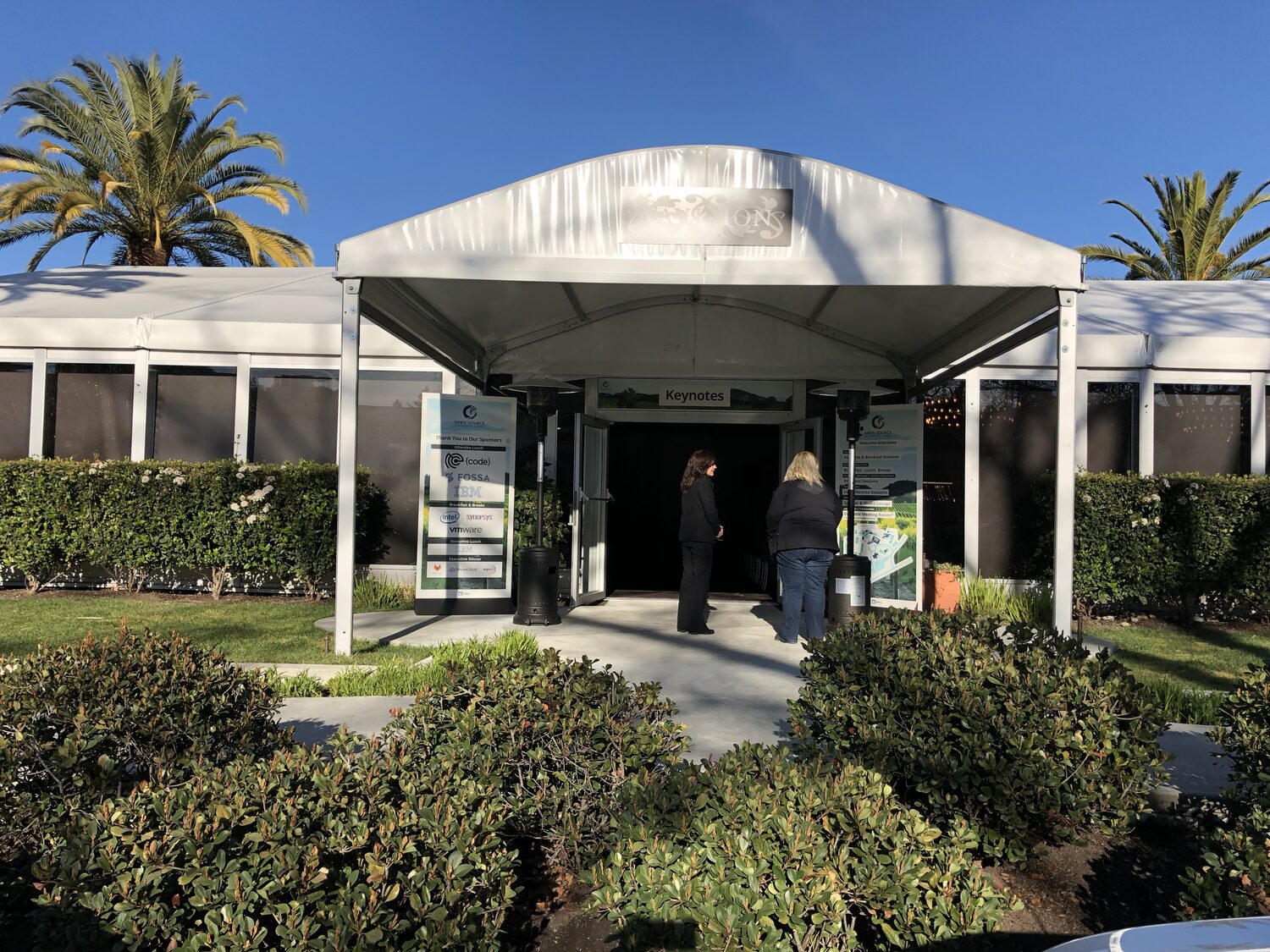 The white marquee entrance to the summit Pavilion, Keynotes signed above the doors, sponsor banner beside it and delegates walking in