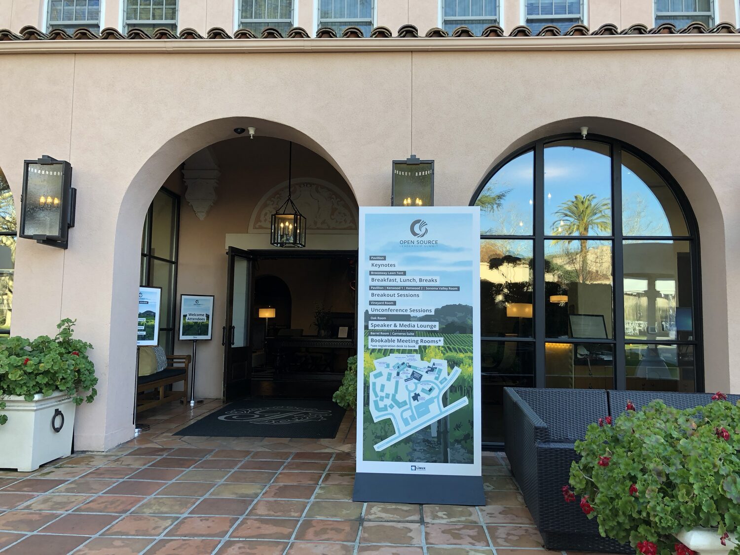 Linux Foundation venue map banner at the hotel entrance listing keynotes in the Pavilion, unconference sessions in the Vineyard Room and the Oak Room as speaker lounge