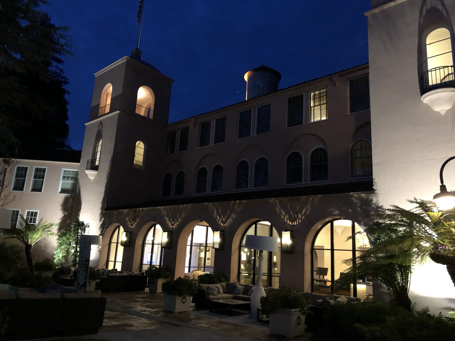 The Fairmont Sonoma Mission Inn courtyard before dawn, arcade windows lit along the ground floor and the bell tower above