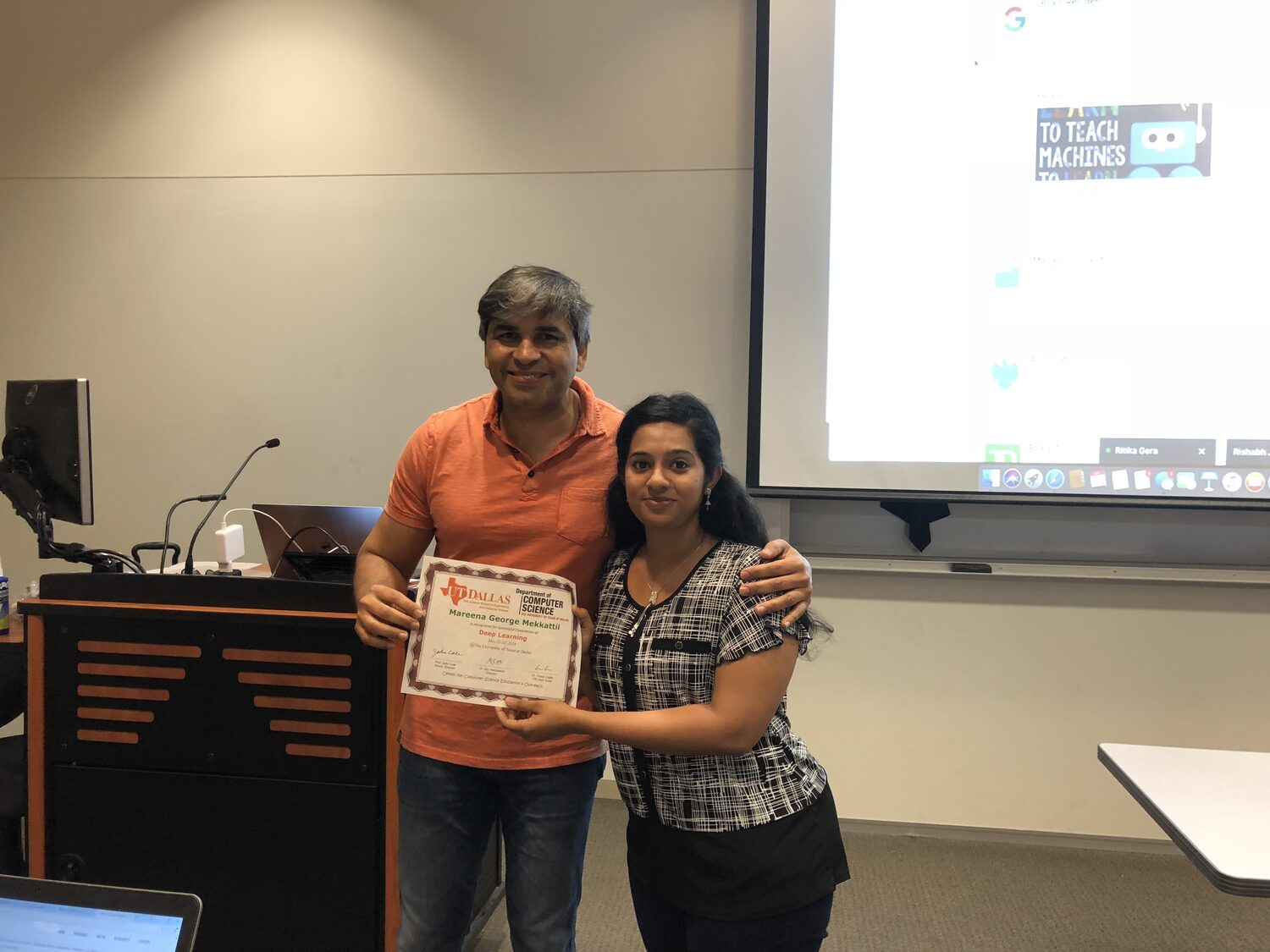 A delegate receives the certificate at the front of the teaching room
