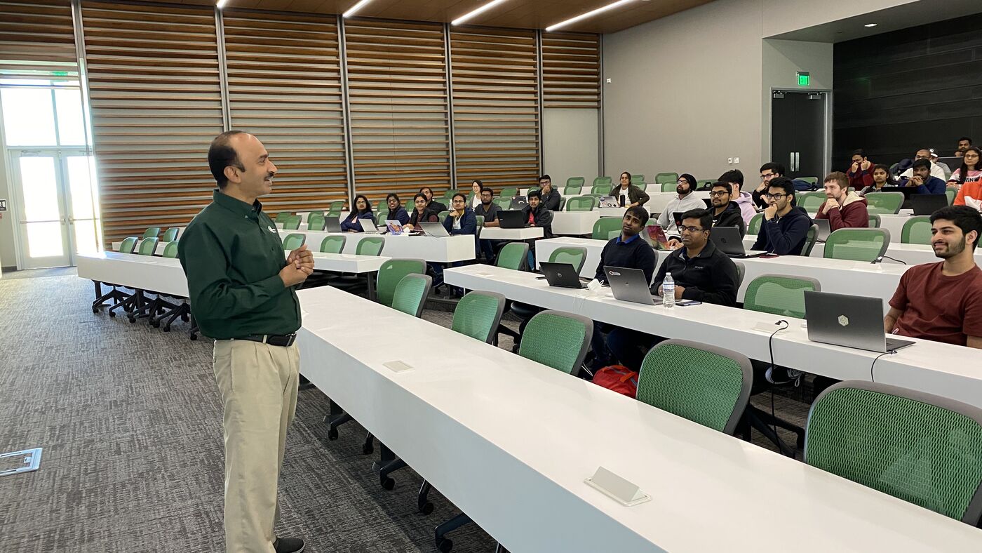 The lecture hall during a session, participants at the benches with laptops open.