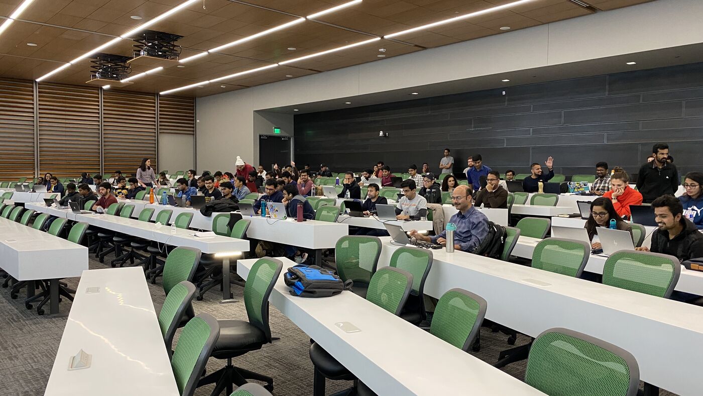 The lecture hall during a session, participants at the benches with laptops open.