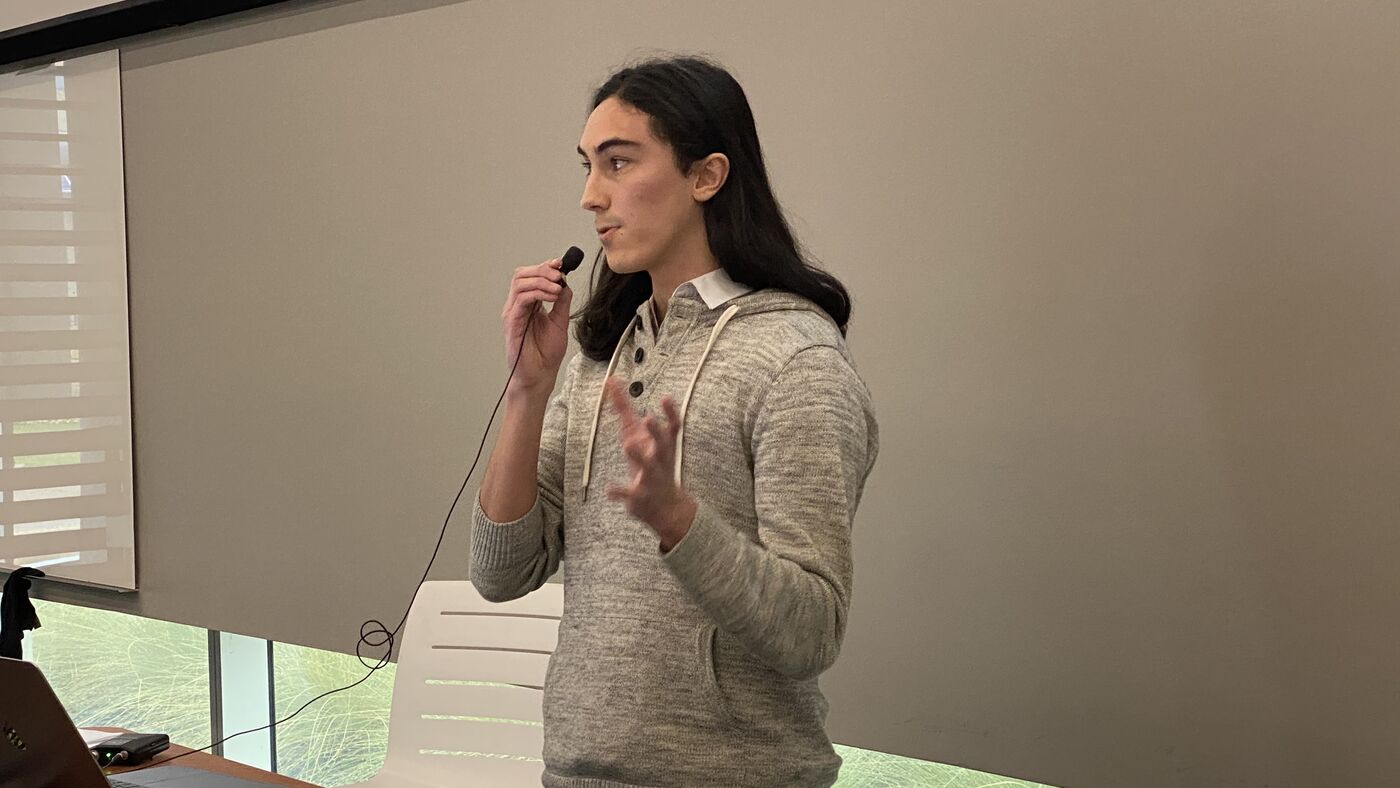 A participant presenting to the room with a handheld microphone.