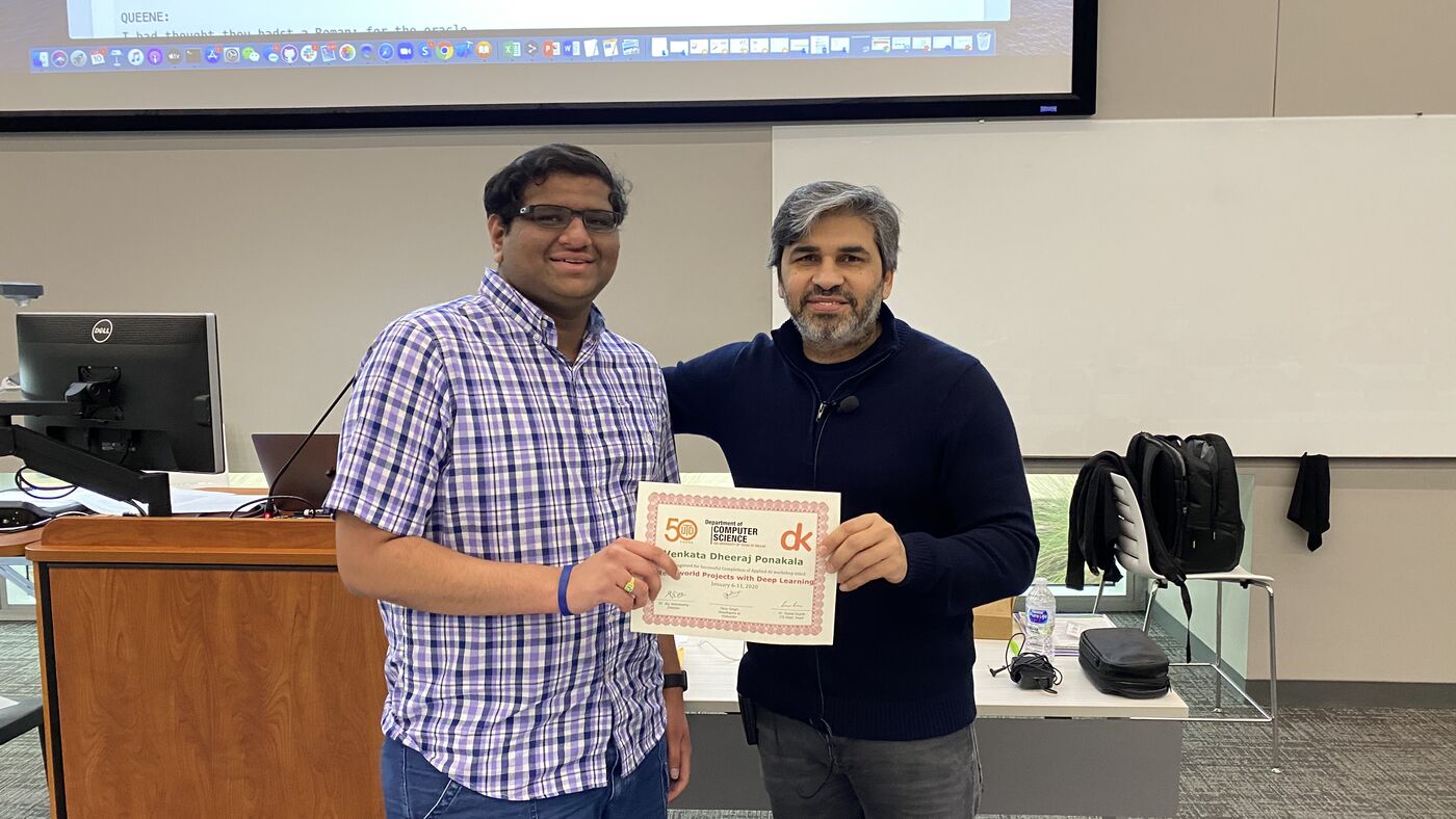 A participant receives the certificate of completion at the front of the hall on the closing day.