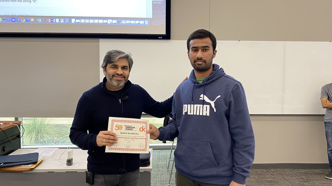 A participant receives the certificate of completion at the front of the hall on the closing day.