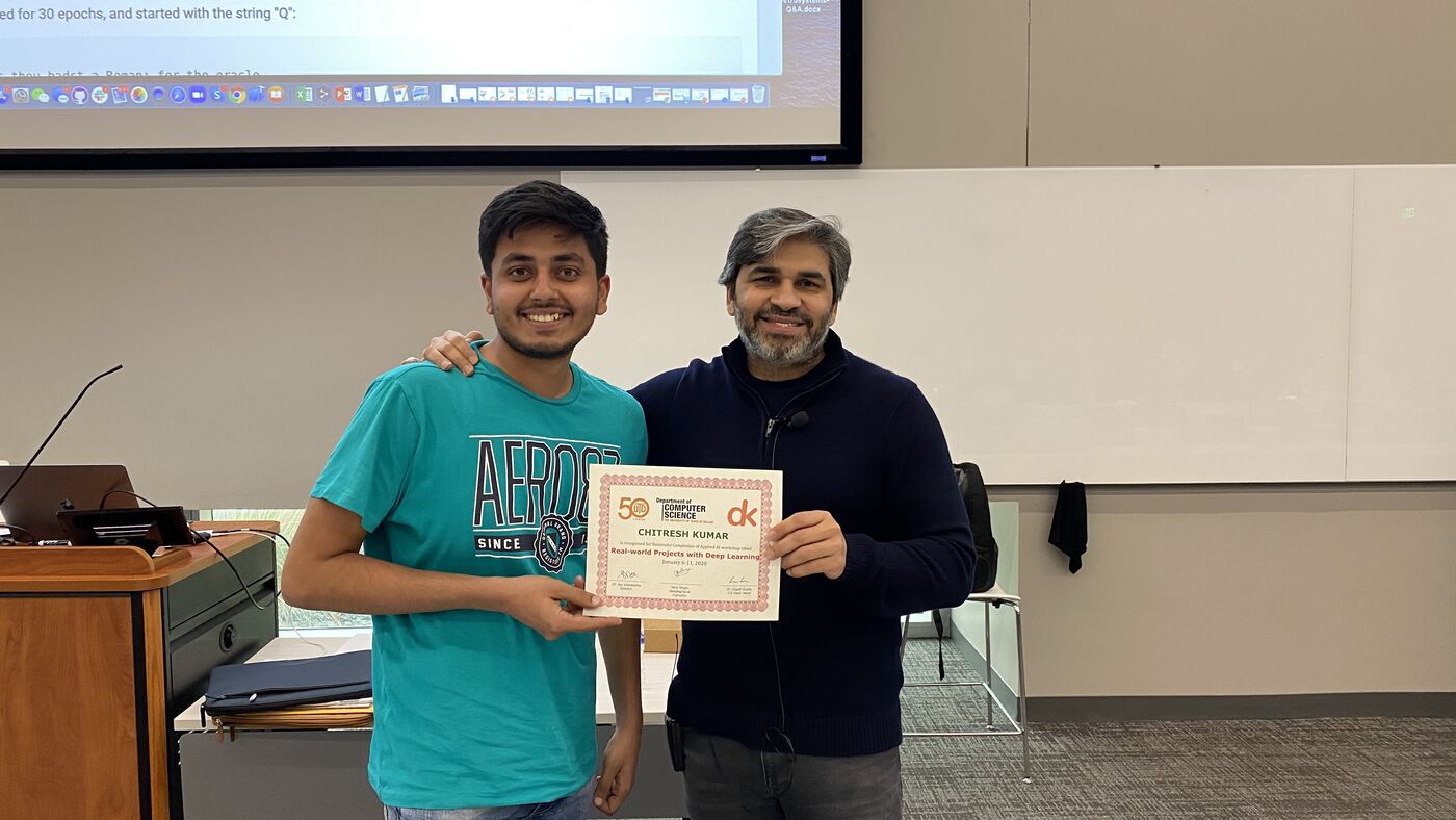 A participant receives the certificate of completion at the front of the hall on the closing day.