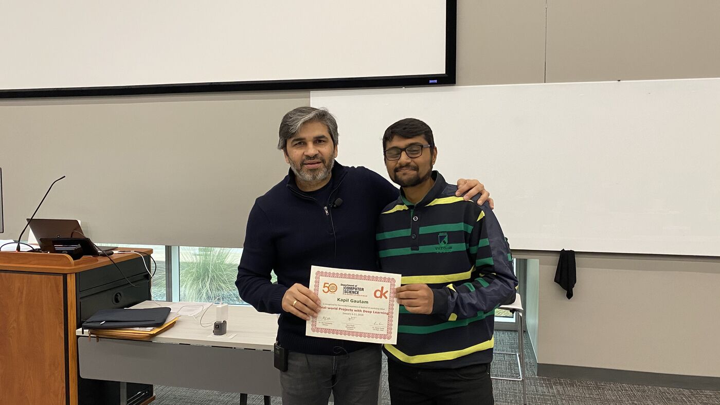 A participant receives the certificate of completion at the front of the hall on the closing day.