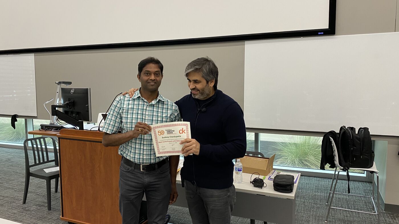 A participant receives the certificate of completion at the front of the hall on the closing day.