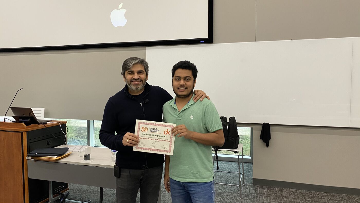 A participant receives the certificate of completion at the front of the hall on the closing day.