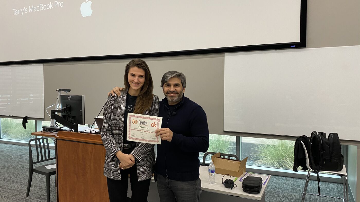 A participant receives the certificate of completion at the front of the hall on the closing day.
