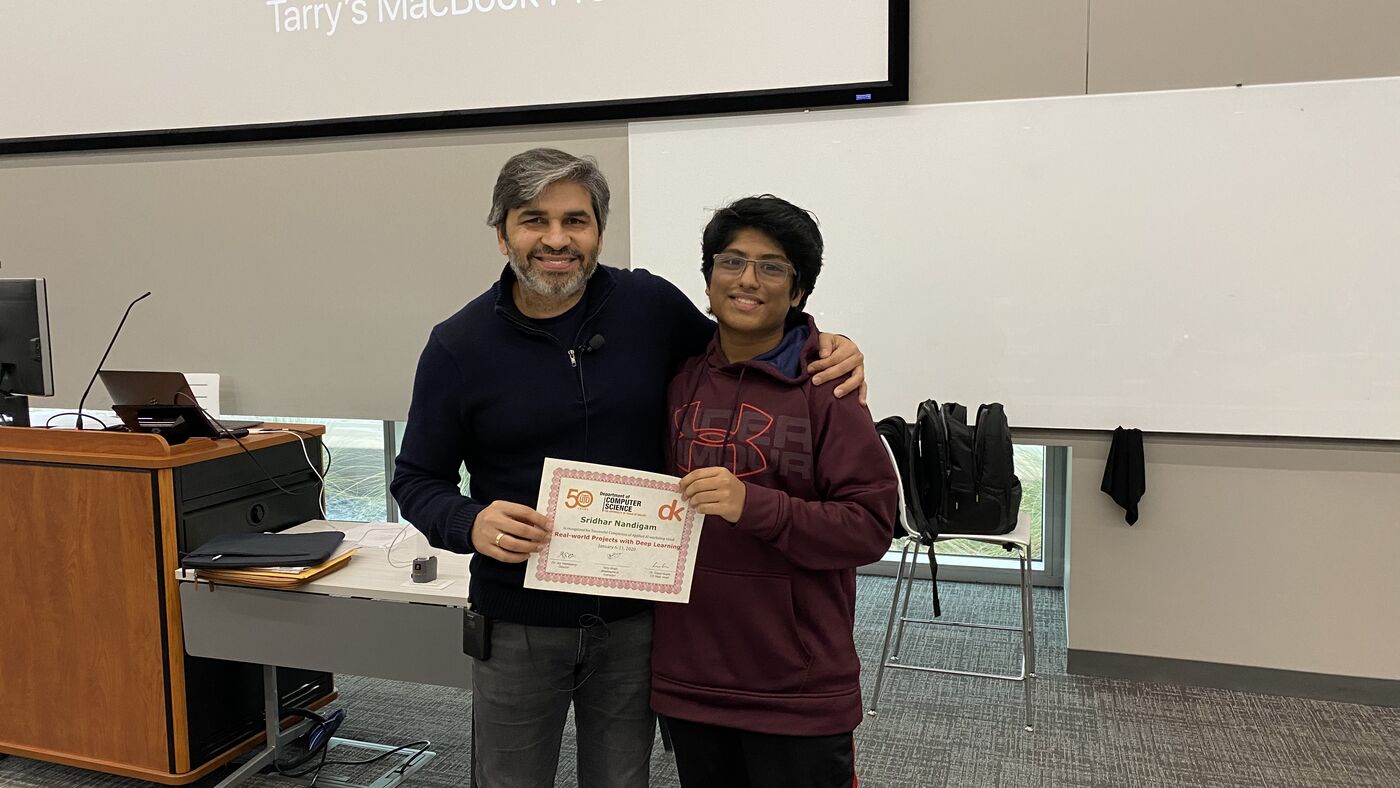 A participant receives the certificate of completion at the front of the hall on the closing day.