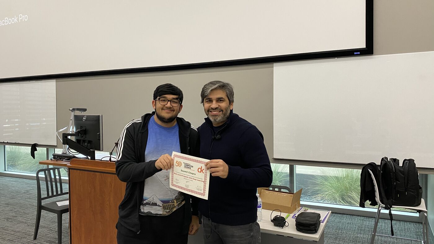 A participant receives the certificate of completion at the front of the hall on the closing day.