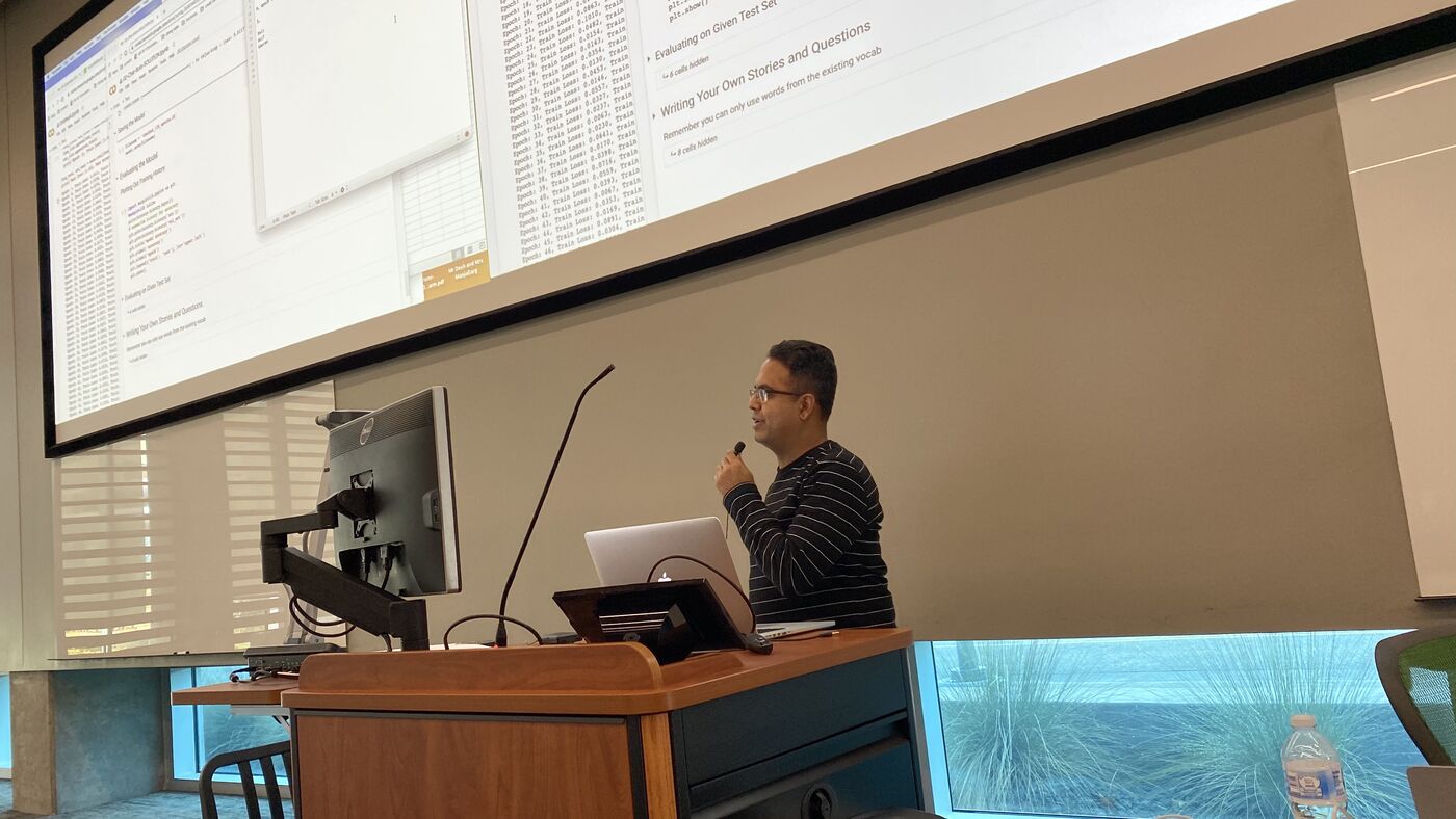 An instructor at the lectern during a session.
