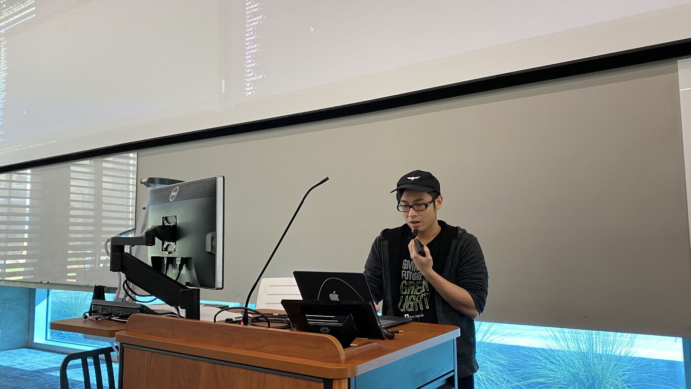 A participant presenting from the lectern with a microphone.