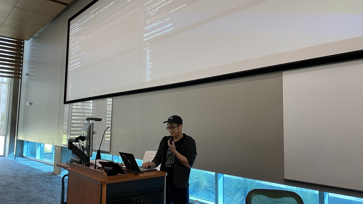 An instructor working through a notebook at the lectern.