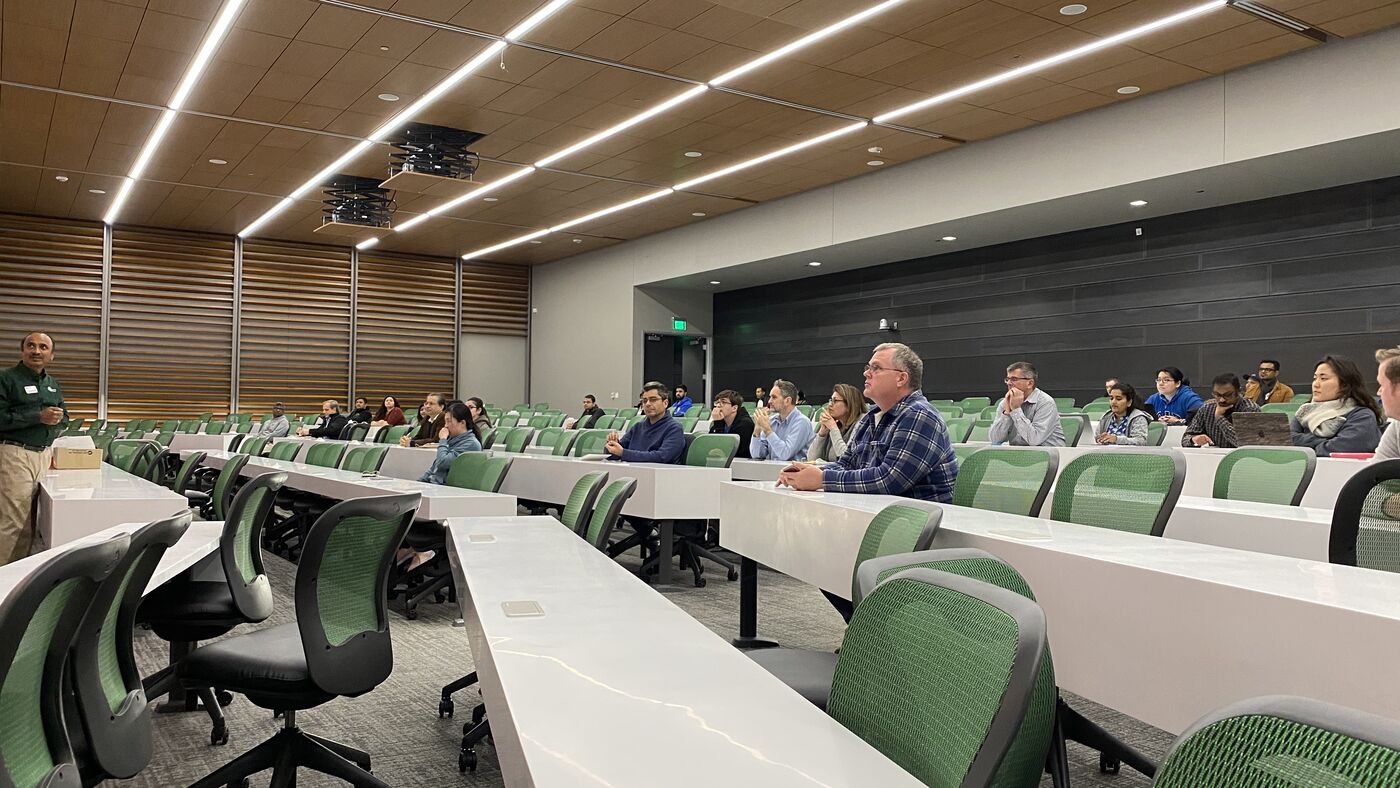 The lecture hall during a session, participants at the benches with laptops open.